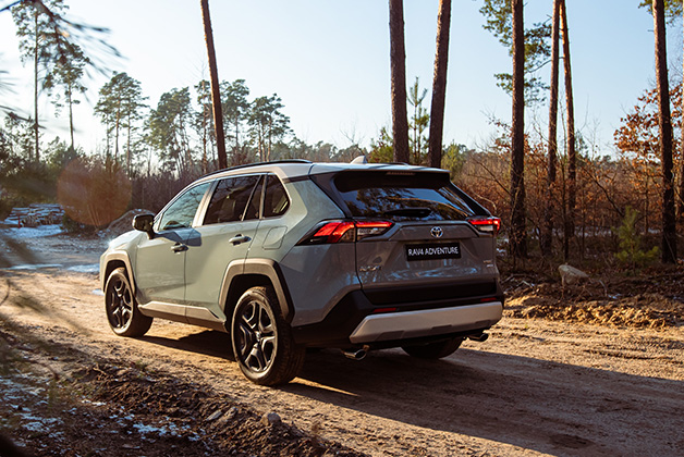 Toyota RAV4 stojąca w słońcu na leśnej drodze