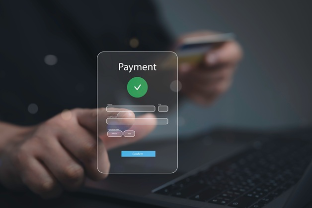 Koncepcja bezpiecznej płatności cyfrowej. Zbliżenie na dłoń wpisującą dane karty kredytowej (numer, data ważności, CVC) do internetowego formularza "Payment" z symbolem sukcesu.