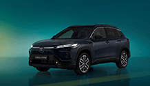 Na zdjęciu jest ciemnoniebieska Toyota Corolla Cross, stojąca na błyszczącej powierzchni, która odbija jego sylwetkę. Tło jest stonowane, w odcieniach turkusu i zieleni, co podkreśla nowoczesny charakter pojazdu.