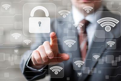 Biznesmen w garniturze dotykający wirtualnej ikony kłódki symbolizującej bezpieczeństwo sieci Wi-Fi, otoczony ikonami sygnału Wi-Fi i zabezpieczeń cyfrowych.