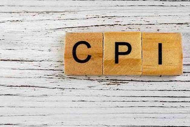 Napis CPI ułożony z drewnianych klocków na drewnianym stole