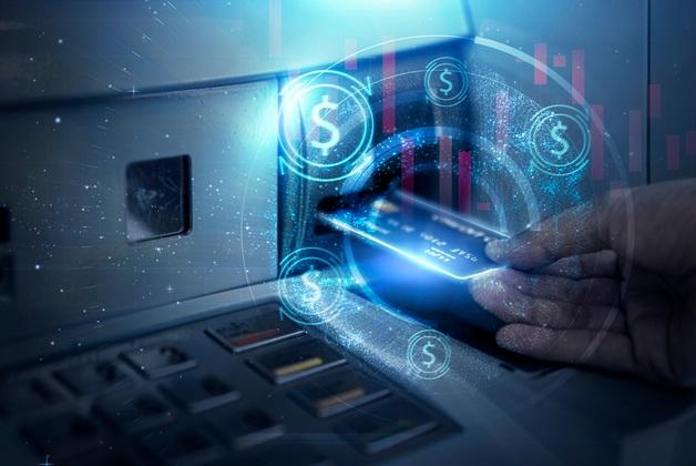 Zdjęcie przedstawiające dłoń wkładającą kartę bankomatową do bankomatu, z cyfrowymi ikonami dolarów i elementami sieciowymi nałożonymi na obraz, symbolizującymi bankowość cyfrową i technologię finansową
