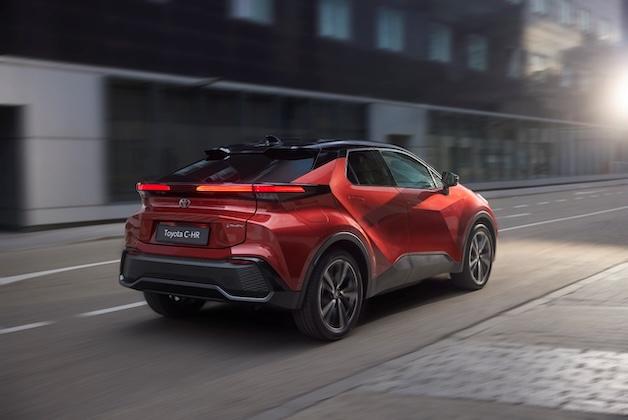 Czerwona Toyota C-HR podczas jazdy miejskiej, zdjęcie wykonane jest od tyłu