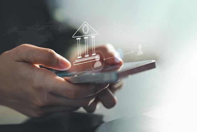 Użytkownik zarządzający finansami przez aplikację mobilną z ikoną e-bankingu.