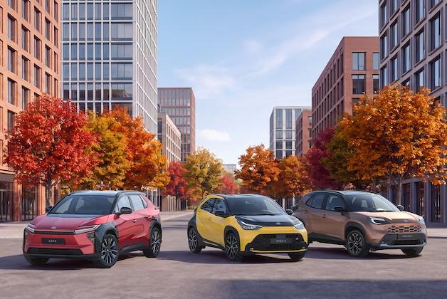Trzy nowoczesne crossovery i SUV-y marki Toyota zaparkowane na miejskiej ulicy jesienią